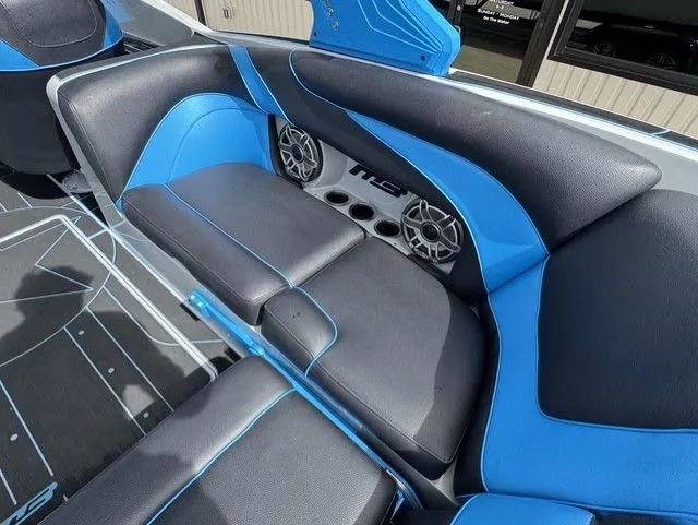 Slide: The Image of The image shows the stylish interior of an MB SPORTS B52 23 Alpha boat with blue and black seating. - 13