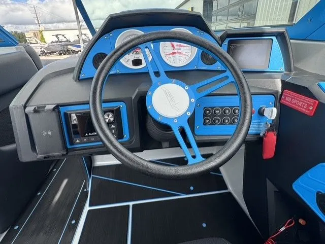 Slide: The Image of The image shows the cockpit of a 2023 MB SPORTS B52 23 Alpha boat with blue accents. - 17
