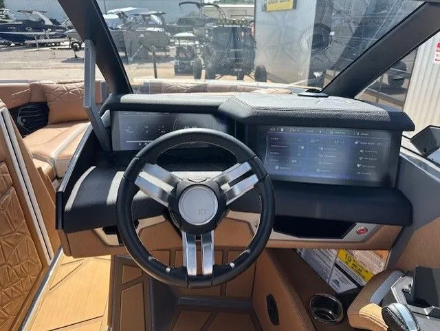 Slide: The Image of The image shows the cockpit of a 2025 Super Air Nautique G25 Paragon with a modern steering wheel and touchscreen. - 25
