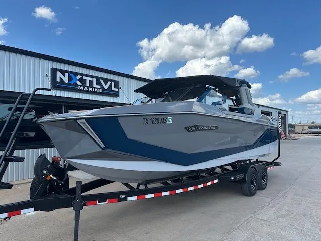 Slide: The Image of A gray and blue boat on a trailer in front of a building. - 2
