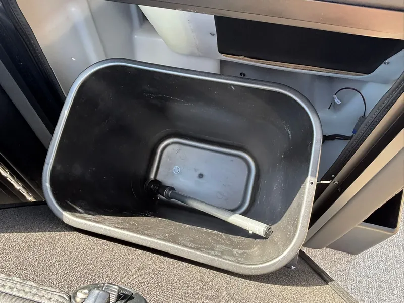 Slide: The Image of A black plastic container with a handle is inside a boat, surrounded by gray surfaces. - 16