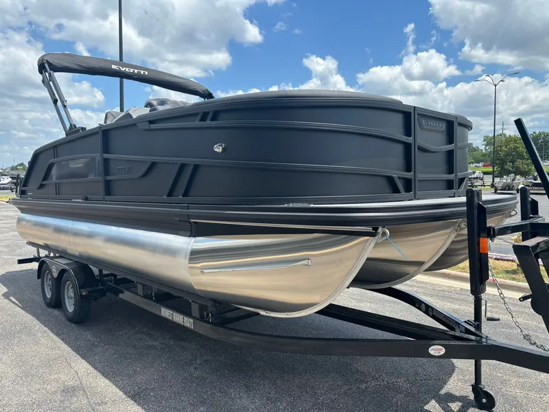 Slide: The Image of The image shows a modern pontoon boat on a trailer. It features a sleek black design. - 4