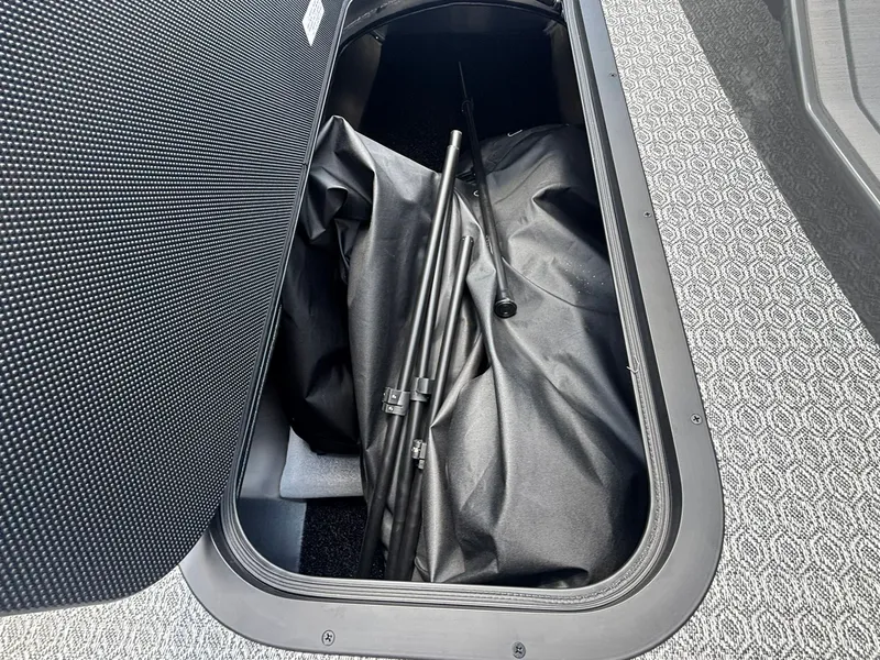 Slide: The Image of A storage compartment in the boat with a black cover and metal rods. - 19