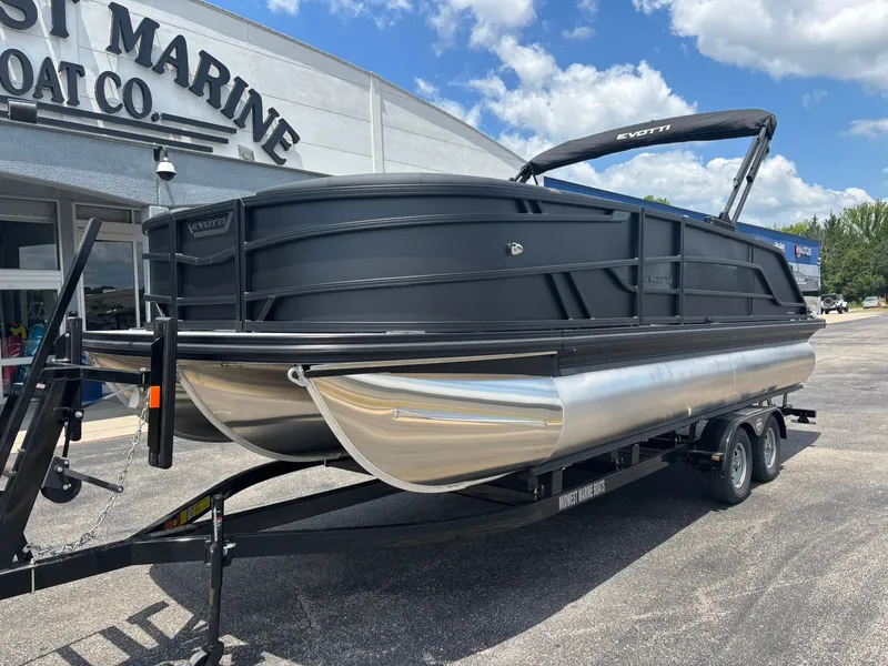 Slide: The Image of The image shows an Evotti 521 QL pontoon boat from 2027 on a trailer outside a boat dealership. - 3