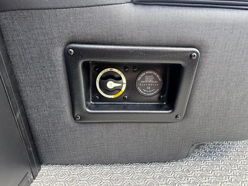 Slide: The Image of Close-up of a boat instrument with a switch and gauge, surrounded by gray upholstery. - 28