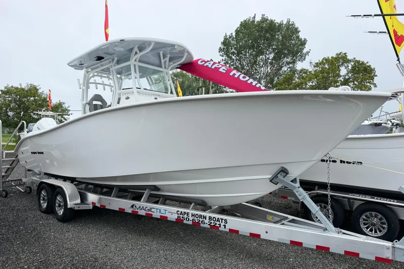 The Image of 2026 Cape Horn 28XS boat on trailer, displayed outdoors with trees in background. - 0