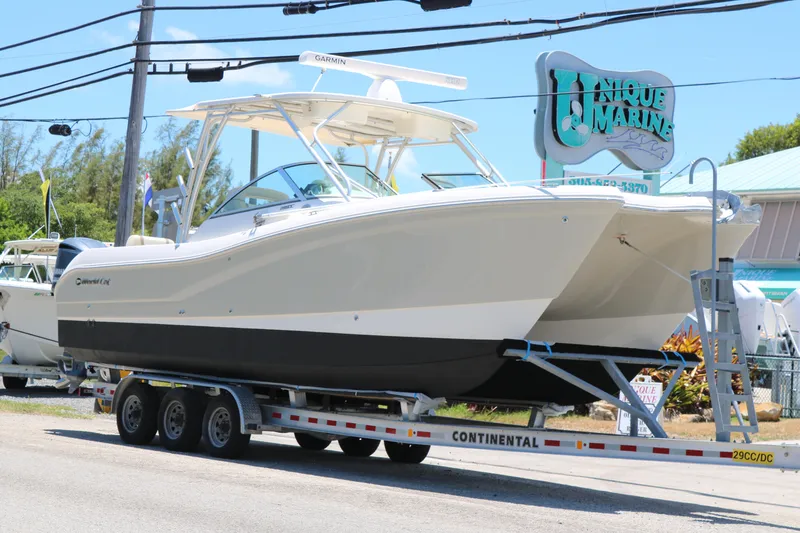 The Image of 2014 World Cat 295 DC boat on trailer at Unique Marine dealership. - 1