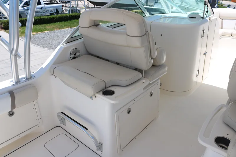 Slide: The Image of 2014 World Cat 295 DC boat interior with white seating and storage compartments. - 10