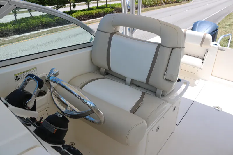 Slide: The Image of 2014 World Cat 295 DC boat helm with steering wheel and comfortable seating. - 6