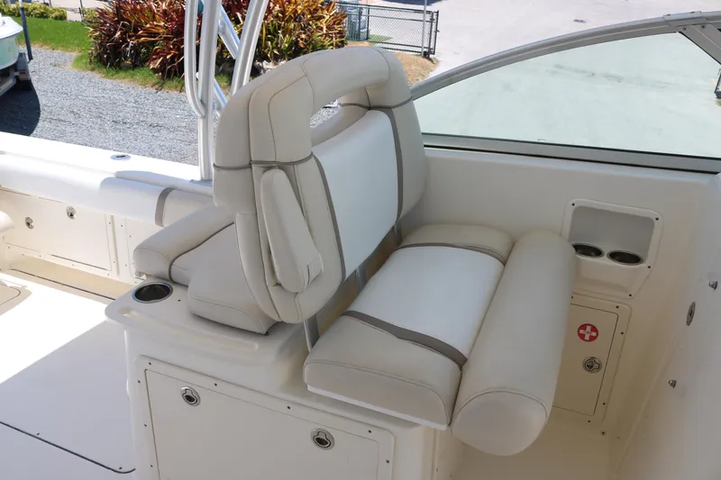 Slide: The Image of 2014 World Cat 295 DC boat interior with beige seating and cup holders. - 9