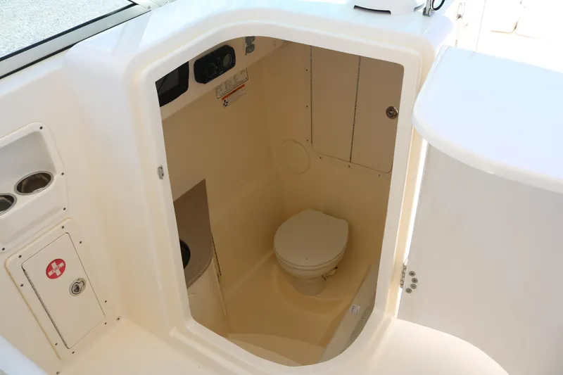 Slide: The Image of 2014 World Cat 295 DC boat interior with compact marine toilet and storage. - 8