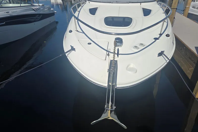 Slide: The Image of 2012 Sea Ray Sundancer 260 docked, showcasing sleek design and anchor. - 26