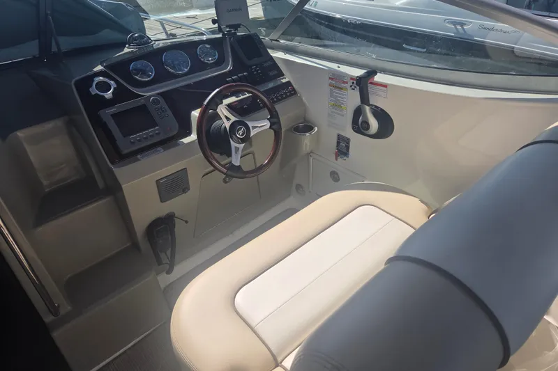 Slide: The Image of Interior cockpit of a 2012 Sea Ray Sundancer 260 boat, featuring steering wheel and controls. - 7