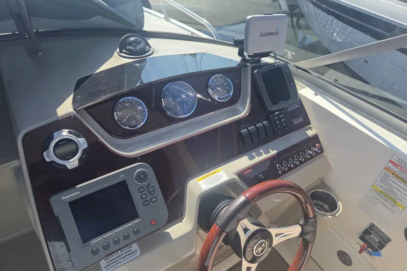 Slide: The Image of 2012 Sea Ray Sundancer 260 dashboard with Garmin and Raymarine navigation systems. - 8