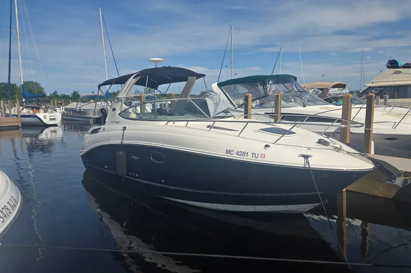 The Image of 2012 Sea Ray Sundancer 260 docked at marina under clear blue sky. - 0