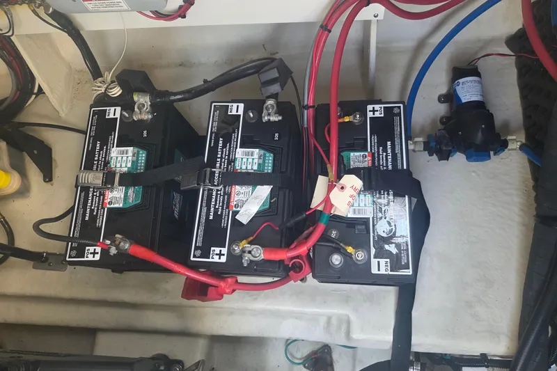 Slide: The Image of Battery compartment of a 2012 Sea Ray Sundancer 260 boat, showing three connected batteries. - 21