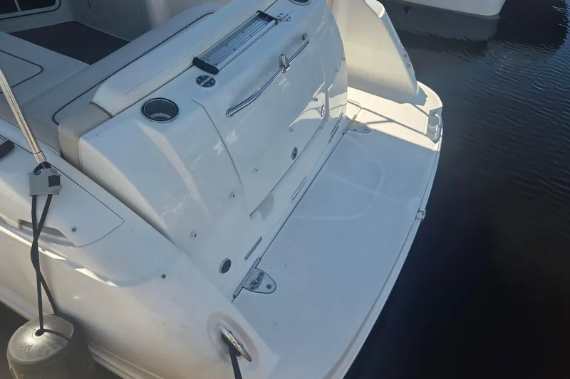 Slide: The Image of Rear view of a 2012 Sea Ray Sundancer 260 boat docked on water. - 23