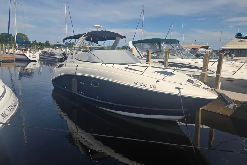Slide: The Image of 2012 Sea Ray Sundancer 260 docked at a marina under a clear blue sky. - 24
