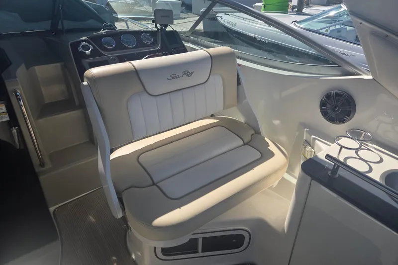 Slide: The Image of Interior of a 2012 Sea Ray Sundancer 260 boat with beige seating and dashboard. - 9