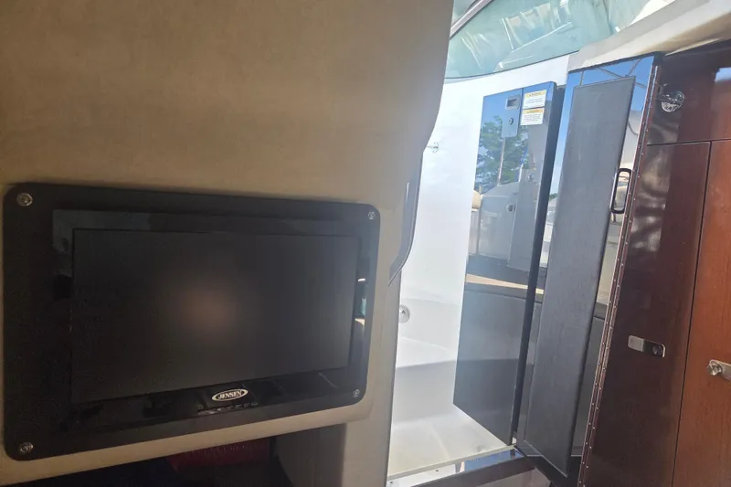 Slide: The Image of Interior view of 2012 Sea Ray Sundancer 260 with TV and cabin door. - 18