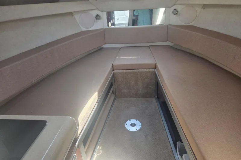 Slide: The Image of Interior cabin of a 2012 Sea Ray Sundancer 260 boat, featuring beige seating. - 14