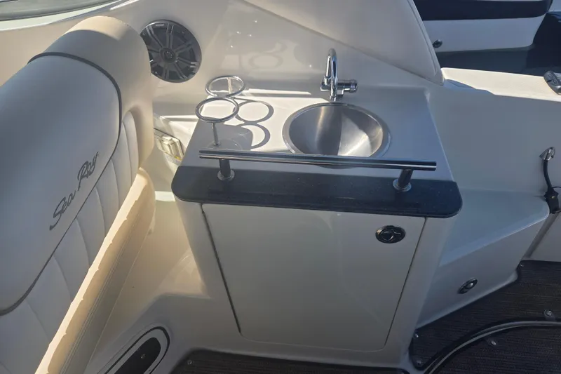 Slide: The Image of Interior of 2012 Sea Ray Sundancer 260 featuring a compact sink and seating area. - 4