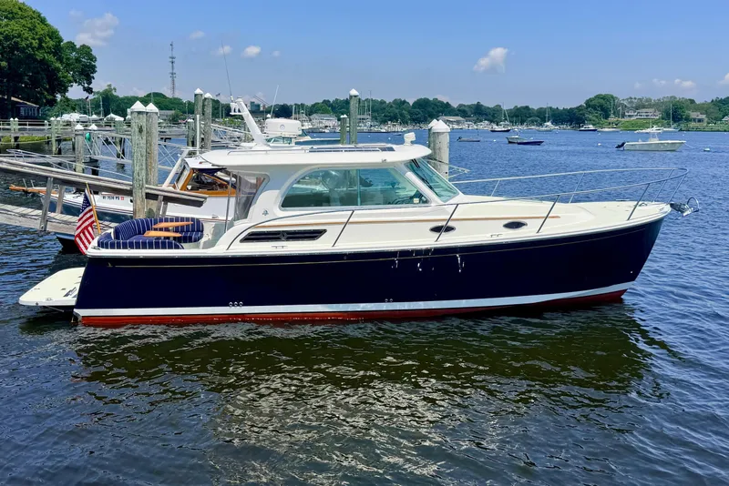 Slide: The Image of A 2018 Back Cove 32 boat docked in a calm harbor setting. - 2