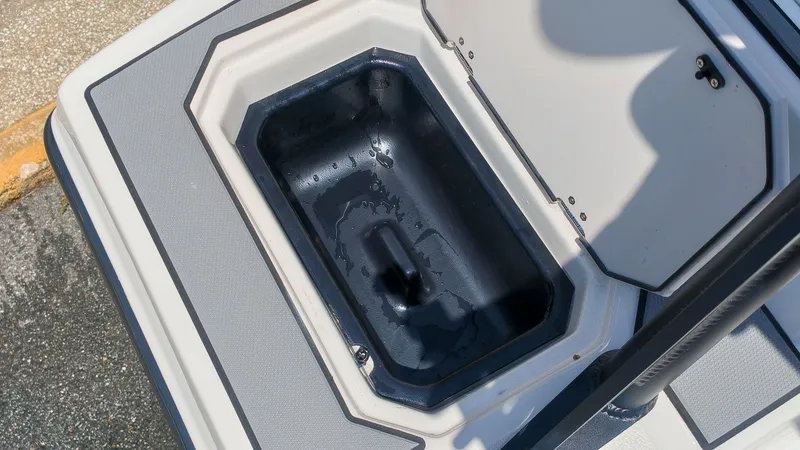Slide: The Image of An open storage compartment on a boat with a gray and white deck. - 7