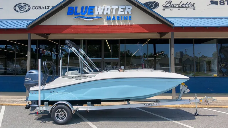 The Image of A Starcraft SV 18 OB boat on a trailer in front of a marine store. - 1