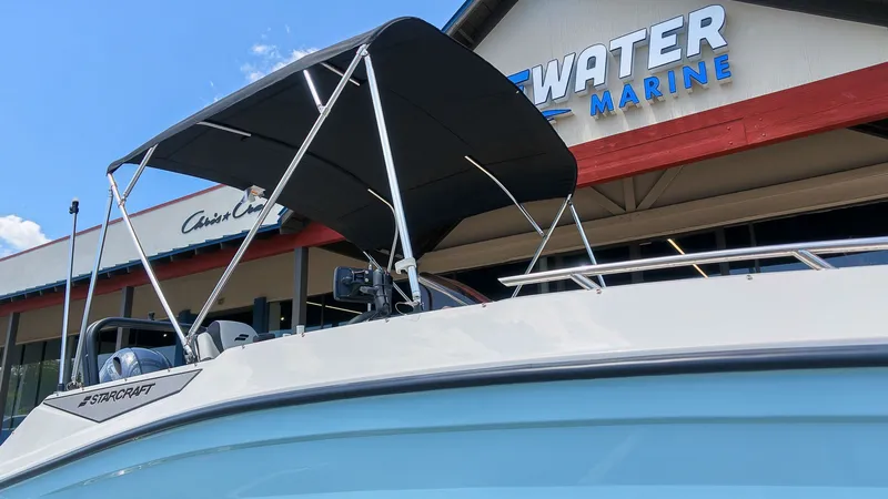 Slide: The Image of A Starcraft SV 18 OB boat with a black sunshade in front of a marine store. - 20