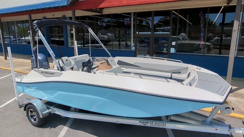 The Image of A 2027 Starcraft SV 18 OB boat on a trailer in front of a building. - 1