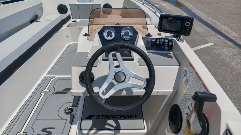 Slide: The Image of Helm of a Starcraft SV 18 OB with steering wheel, gauges, and screen. - 17
