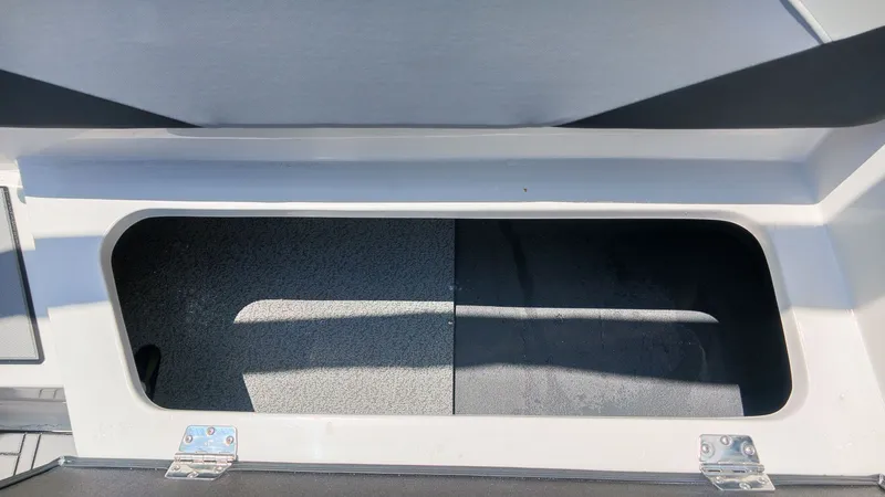 Slide: The Image of Boat storage compartment with gray carpeted floor. - 8