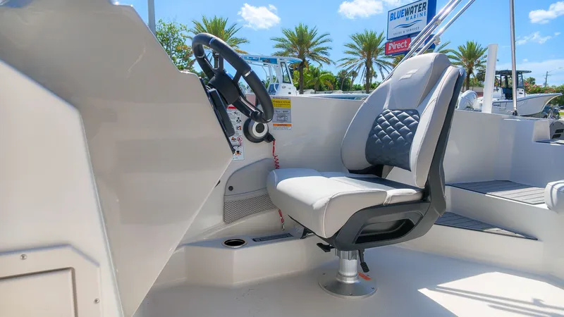 Slide: The Image of The image shows the helm of a Starcraft SVX 211 OB boat with a cushioned seat. - 18