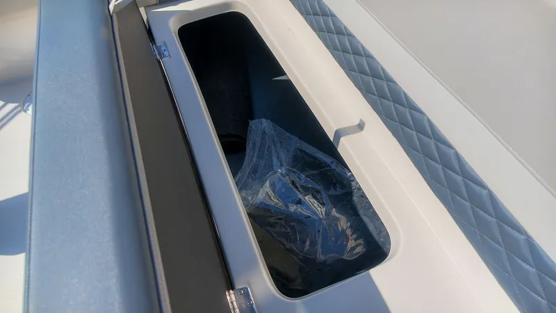 Slide: The Image of Storage compartment in a boat with blue upholstery and black lid. - 10