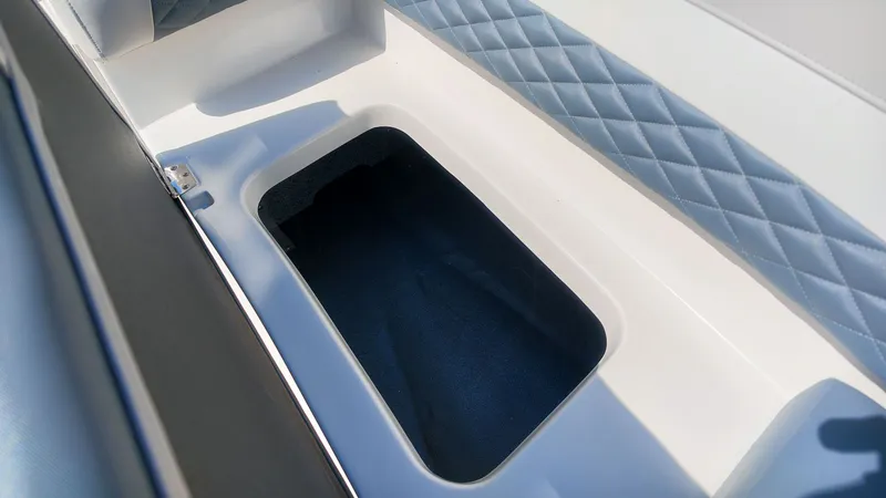 Slide: The Image of An open storage compartment on a boat with cushioned seating and blue upholstery. - 14
