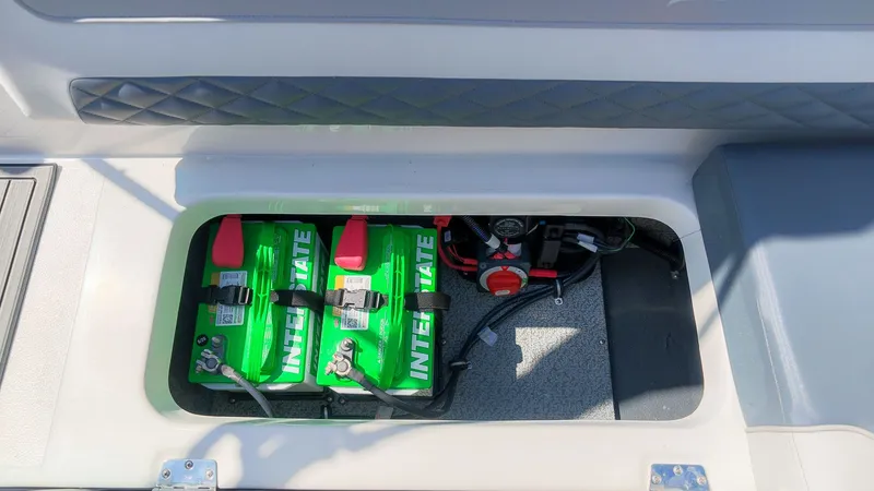 Slide: The Image of The image shows two green batteries in a boat storage compartment. - 8