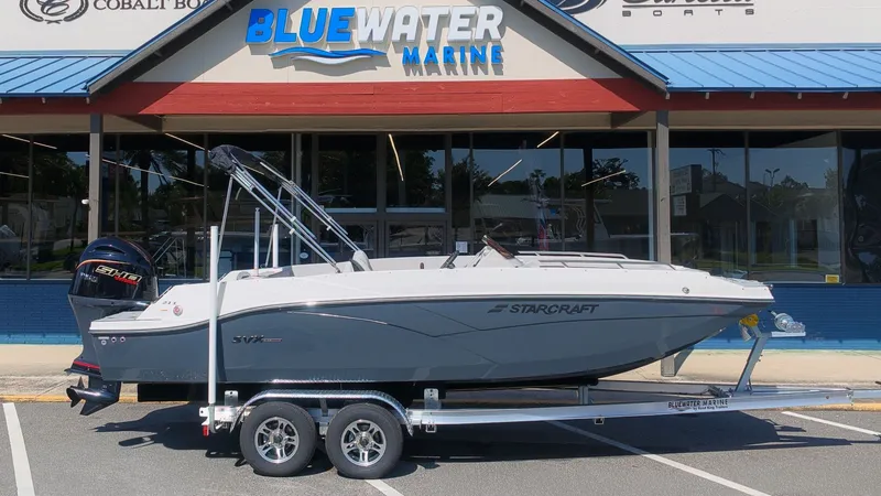 Slide: The Image of Starcraft SVX 211 OB boat parked on a trailer in front of a marine store. - 22