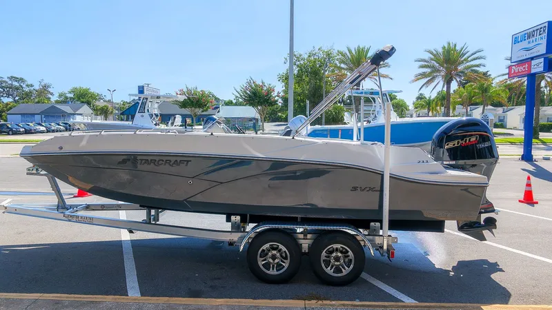 The Image of A gray Starcraft SVX 211 OB boat from 2027 is on a trailer in a parking lot. - 1