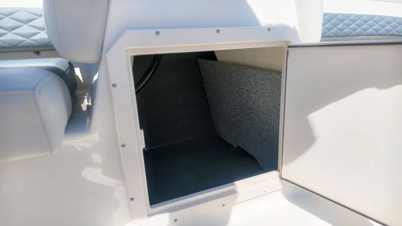 Slide: The Image of An open storage compartment on a boat with cushioned seating and a gray interior. - 11