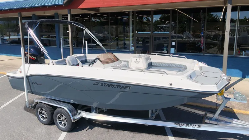 Slide: The Image of A gray Starcraft SVX 211 OB boat from 2027 on a trailer in front of a building. - 23