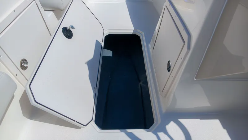 Slide: The Image of Open storage compartment on a boat with white hatches and blue interior lining. - 16
