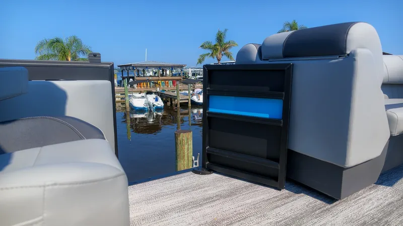 Slide: The Image of The image shows the deck of a 2027 Bennington 21 S Swingback boat, overlooking a calm marina. - 14