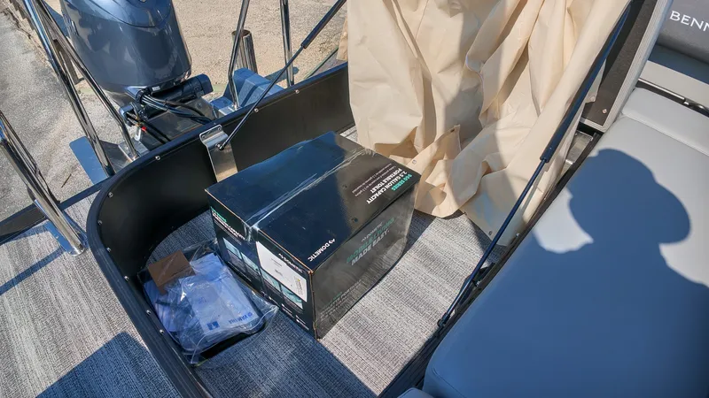 Slide: The Image of The image shows the deck of a 2027 Bennington 21 S Swingback boat with a box and accessories. - 9