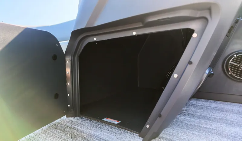 Slide: The Image of An open storage compartment on a Bennington 21 S Swingback boat, featuring gray flooring. - 16