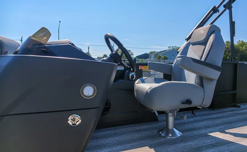 Slide: The Image of The image shows the helm of a Bennington 21 S Swingback boat with a gray seat and steering wheel. - 17