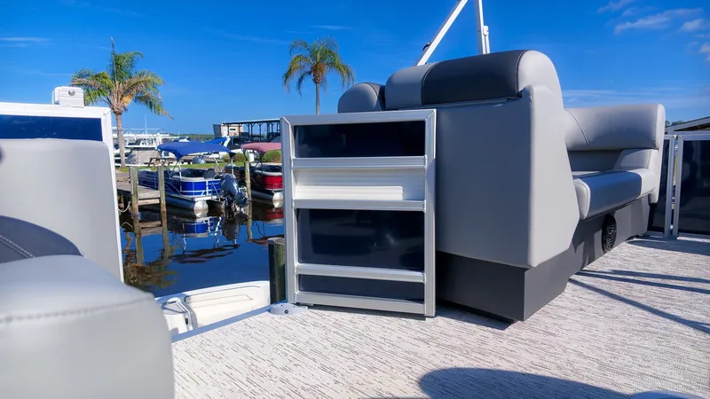 Slide: The Image of A modern pontoon boat with gray upholstery and sleek design, docked on a sunny day. - 16