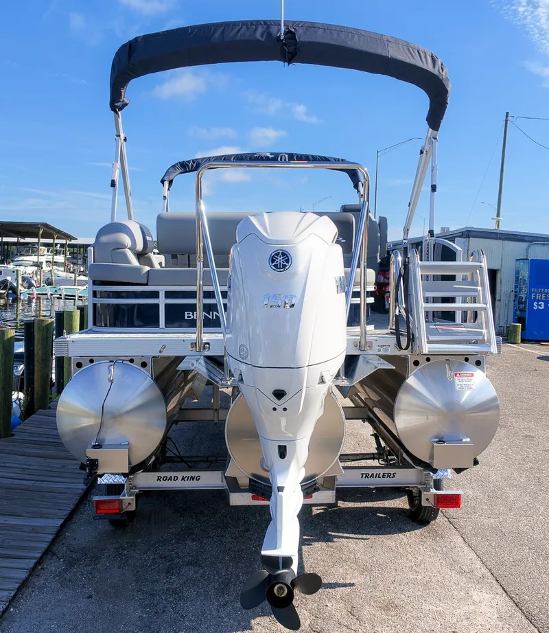 Slide: The Image of A 2027 Bennington 22 S Swingback pontoon boat with a large outboard motor and sunshade. - 5