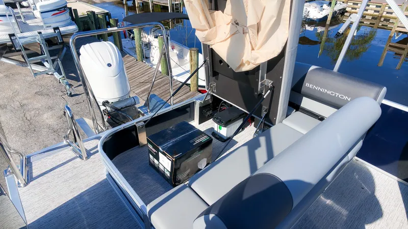 Slide: The Image of The image shows the stern of a Bennington 22 S Swingback pontoon boat with gray seating and an outboard motor. - 8