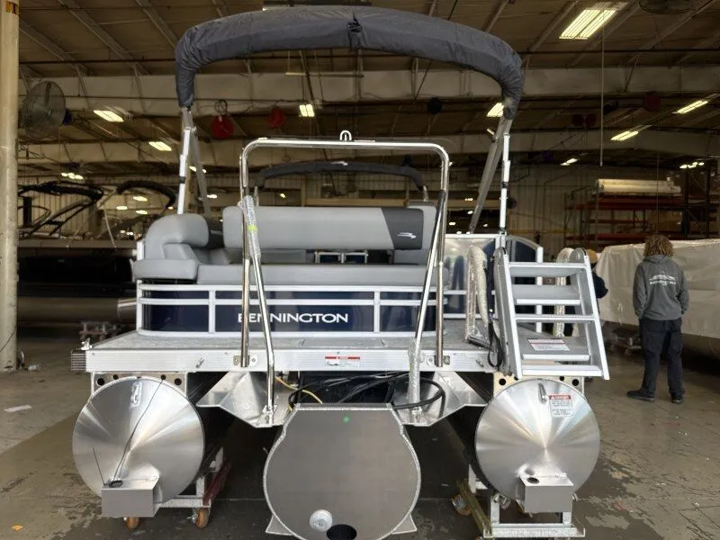 The Image of The image shows a Bennington 22 S Swingback pontoon boat in a warehouse. - 1